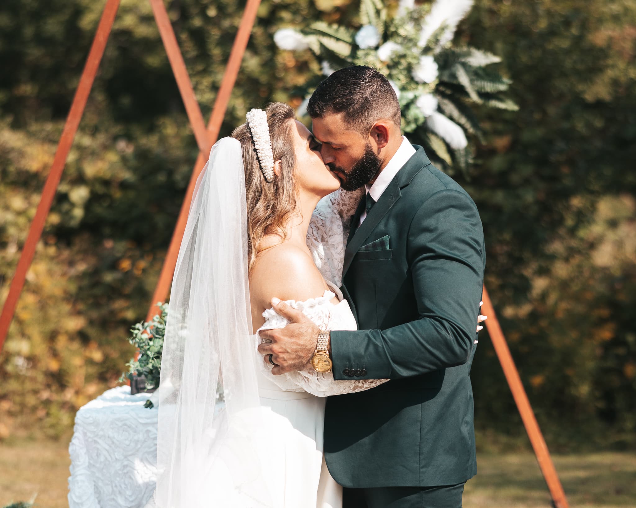 First kiss at outdoor wedding ceremony